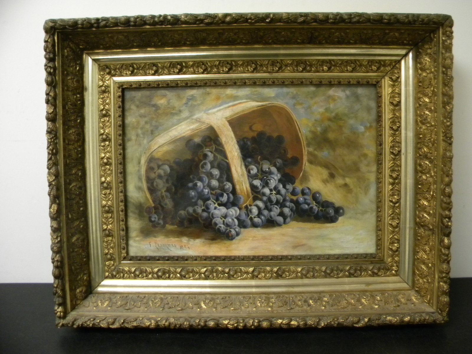 Signed Oil on Canvas: SLL, "F. Peddicord", dated 1894. Clusters of blueberries in basket laying on its side. Hosue on in ornate deep well gitl frame hand deocated in acorns and oak leaves. Exposed, 18.5"x12.5" and frame 28