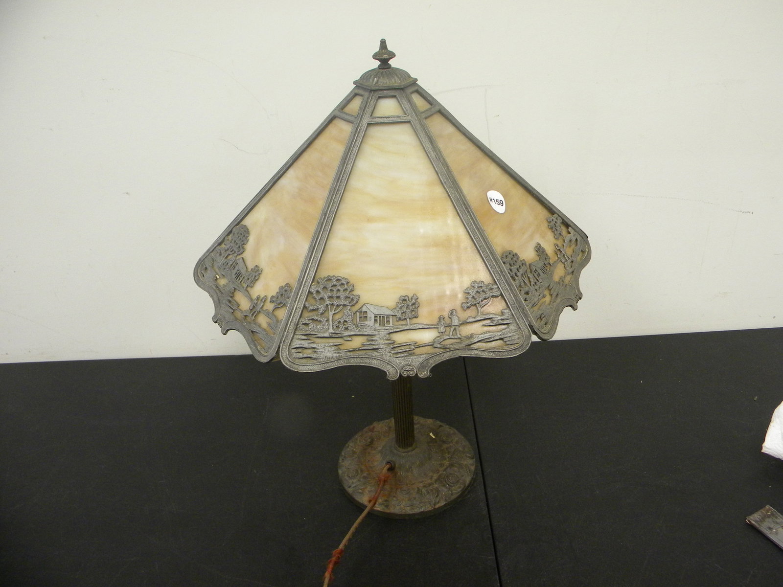 Antique Miller Slag Glass Lamp: scenic metal work on shade, six caramel panels. Decorative rose design on base of lamp, 23"x17".