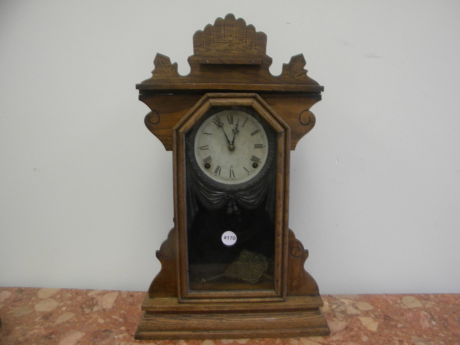 Gilbert Carved Gingerbread Clock: has key/pendulum, fancy tassel and curtain metal fixture around face 15"x23".