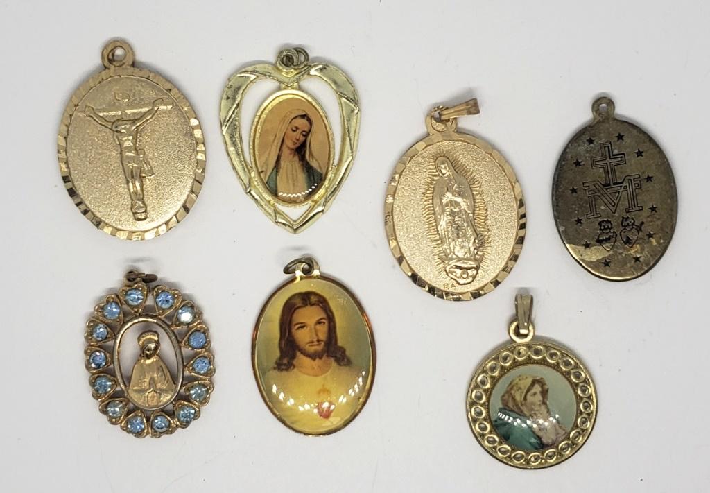 7-VINTAGE GOLD TONED RELIGIOUS PENDANTS: (1)WITH LIGHT BLUE HEART SHAPED RHINESTONES AROUND BOARDER
