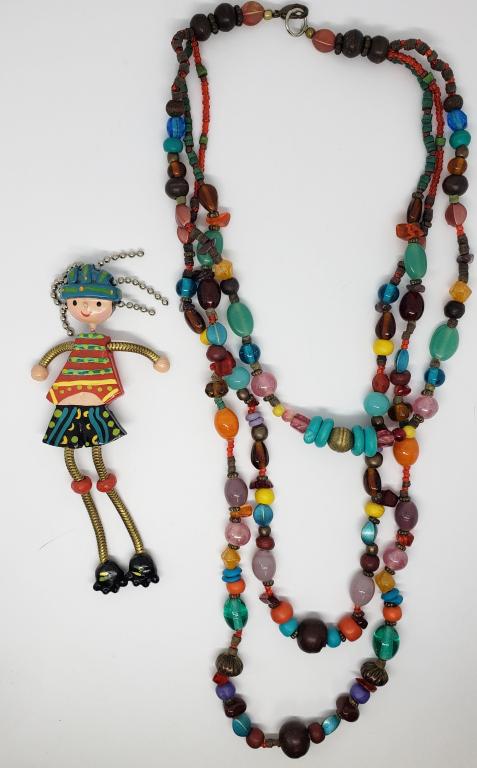 VTG MULTI COLORED TRIPLE STRANDED NECKLANCE: WITH HAND PAINTED DANGLY LEGGED SKATER BROOCH