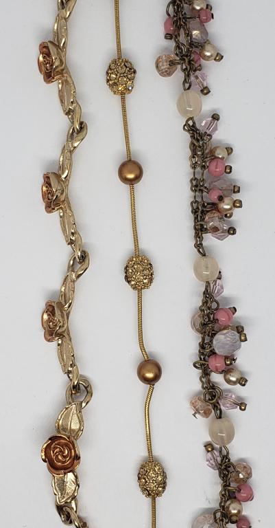 3-VINTAGE GOLD TONED BRACELETS: (1)AVON: WITH ROSE GOLD TONED ROSES (1)WITH DANGLY BEADED CHARMS (1)WITH GOLD TONED AND BROWN BEADED ACCENTS