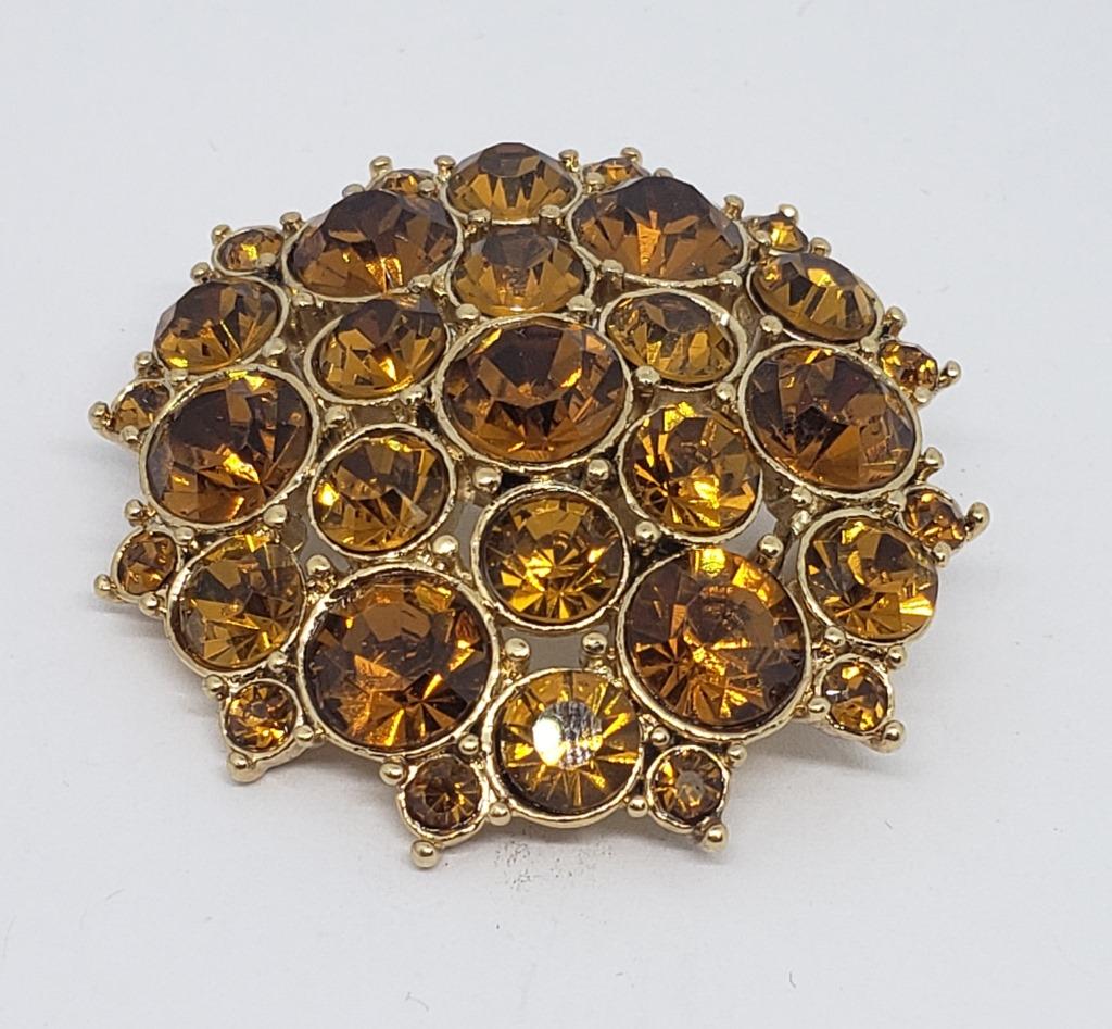 VINTAGE MONET GOLD TONED BROOCH WITH: ORANGE RHINESTONES