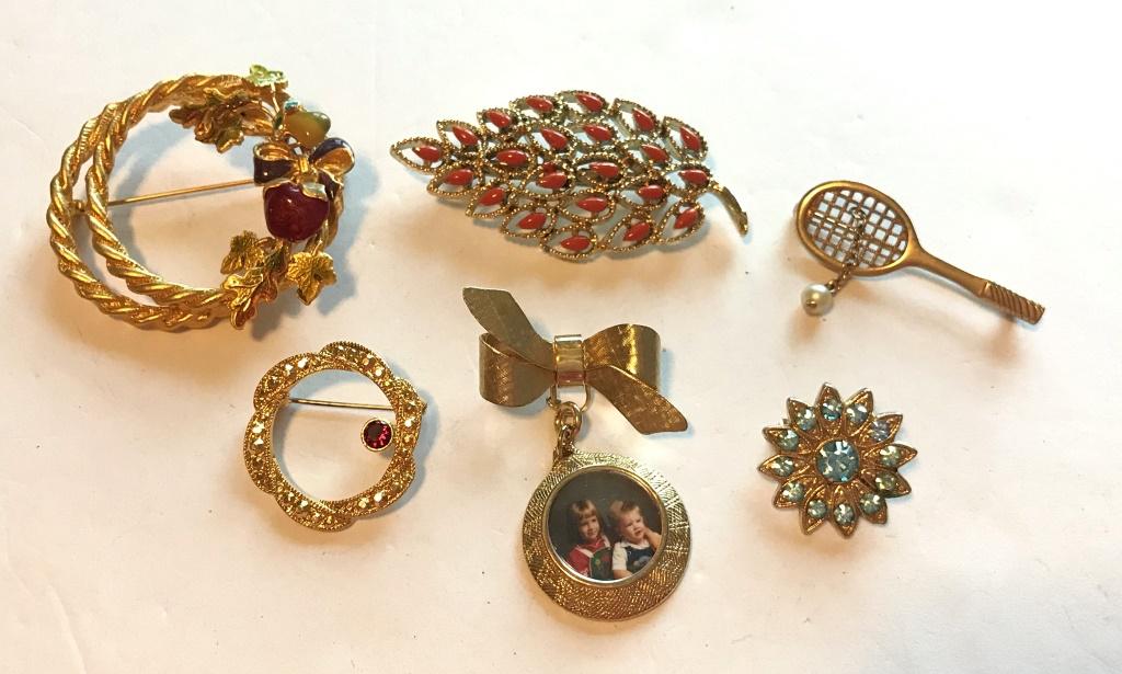 6 GOLD TONE BROOCHES: RACKET, BOW, WREATH, PICTURE, LEAF, STARBURST, BLUE RHINESTONE, RED, ORANGE