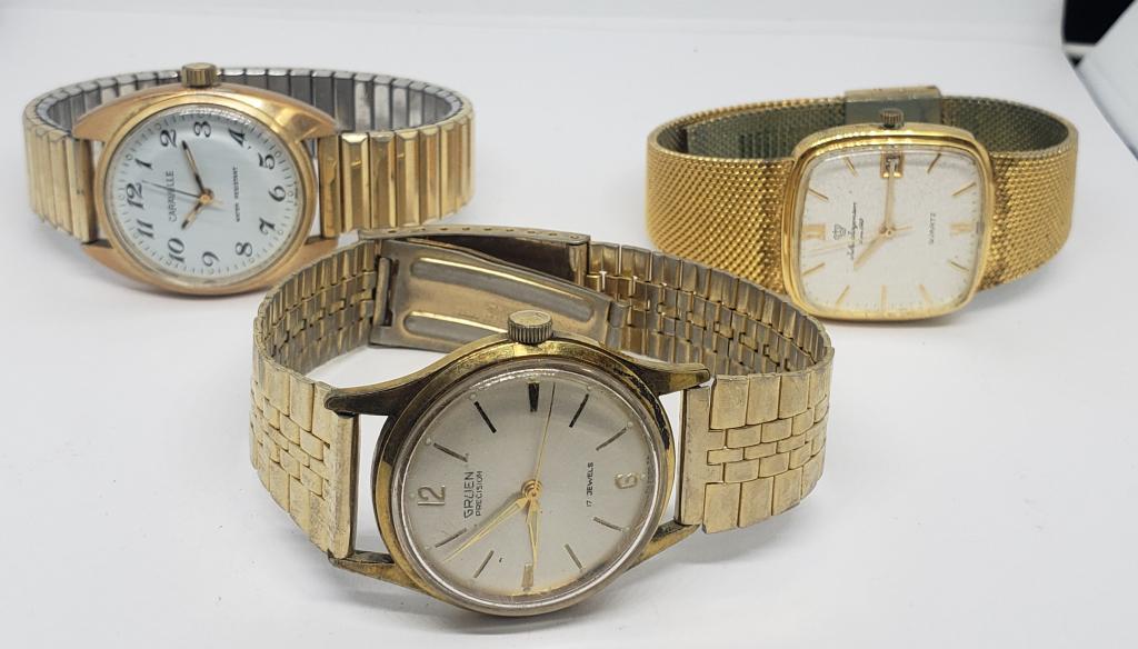 3-VINTAGE GOLD TONED MEN'S WRISTWATCHES: (1)JULES JURGENSEN QUARTZ DAY DATE (1)CARAVELLA WATER RESISTANT (1)GRUEN PRECISION 17 JEWELS