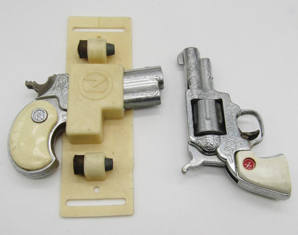 (2) NICHOLS SMALL CAP GUNS: (1) w/ORIGINAL PLASTIC HOLDER & PLAY BULLETTS
