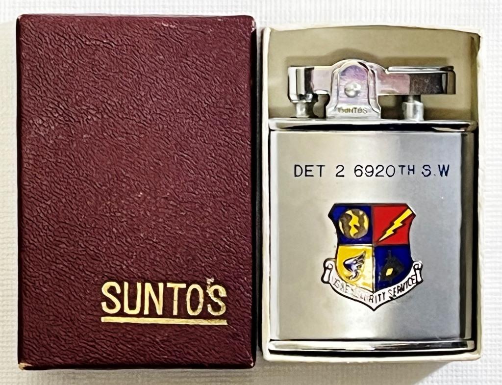 Suntos Ashtray-Lighter With Security Logo: Silver tone, Vintage SUNTOS Lighter, Marked " Suntos" "Automatic Super Ashtray Lighter" " PAT NO. 10448" "JAPAN", Has USAF Security Service Logo on front, Comes in SUNTOS box.