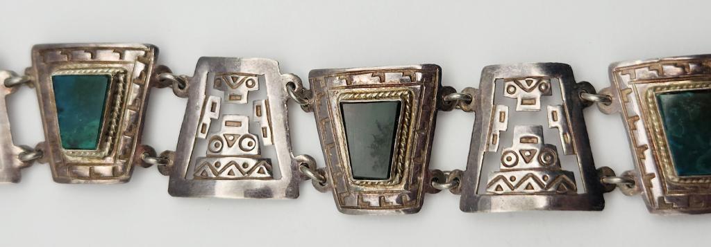 VINTAGE PERU INCA MOTIF PANEL BRACELET: WITH GREEN INLAYY STONE ACCENTS-MEASURES 7 INCHES-TOTAL 12 DWT
