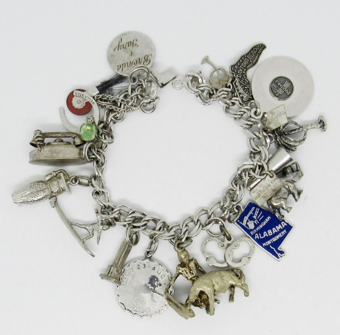Sterling Charm Bracelet w/17 charms: 32dwt, 71in, some charms include an owl, surfer, palm tree,old time phone to just new some,with a open box clasp, stamped with JB in a triangle sterling, also stamped pat 3308517