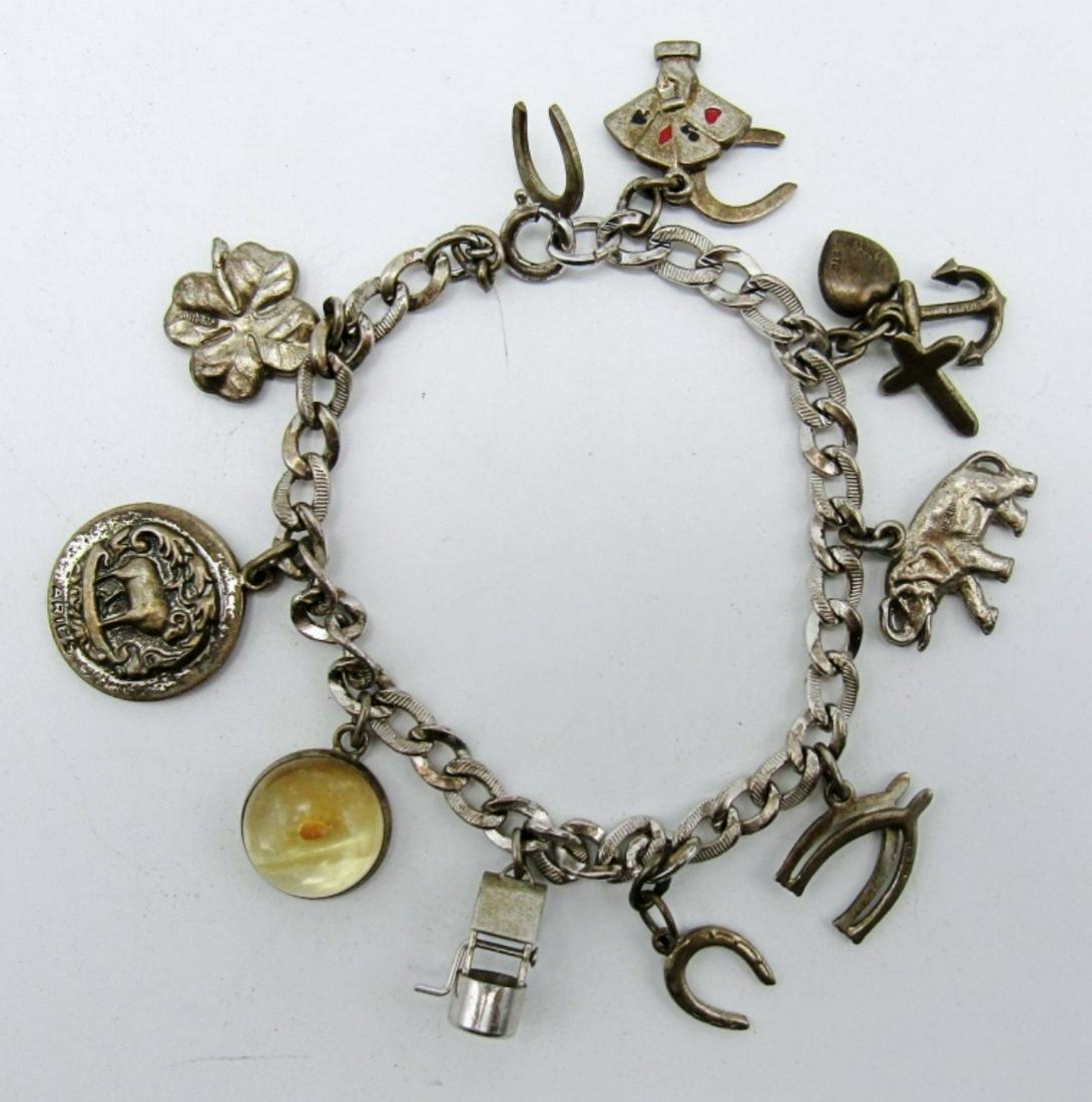 Vintage Sterling Charm Bracelet: 14dwt,7in 13 charms some charms include horse shoes, playing cards, a well,elephant etc.., all marked charms and chain sterling