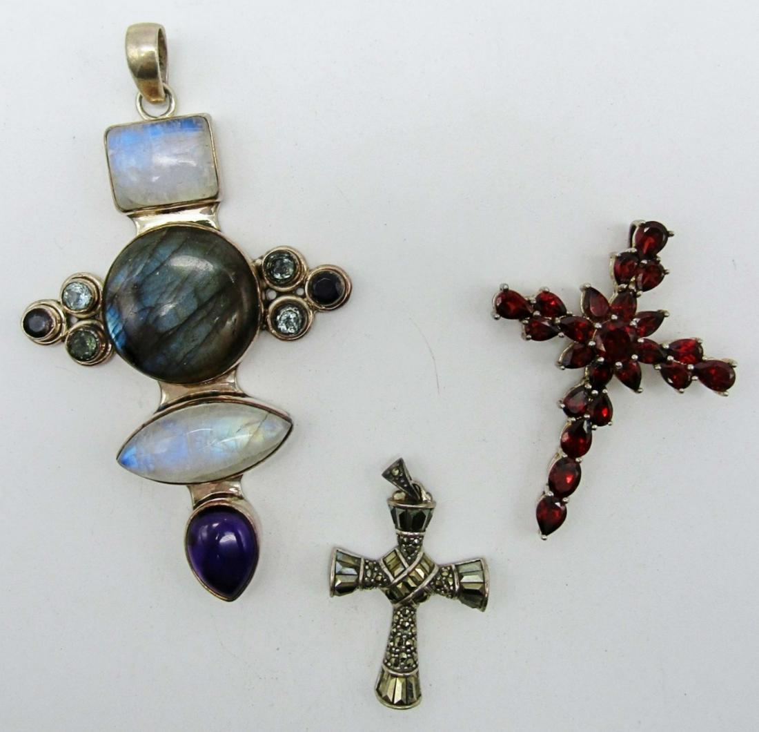 (3) 925 Cross Pendants: 30dwt, 1- marcasite stones all over cross stamped A925 Thailand 2in length, 2 1/2in length with red stones stamped 925 on back, 4in long cross had natural stones all along stamped 925 on back