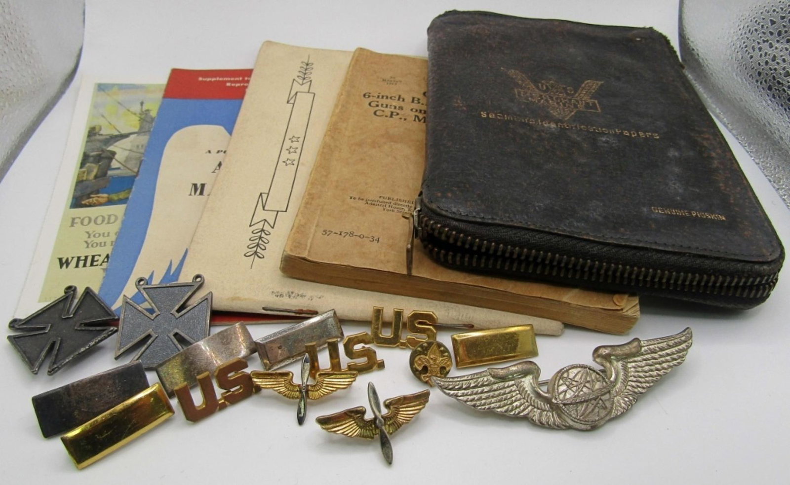 WWII LOT PINS, BOOKS & LEATHER CASE: (14) VARIOUS PINS: SOME MISSING BACKS, 2 STAMPED "STERLING" 1 STAMPED "SILVER". (2) MILITARY MANUALS: 1934 GUN DRILL & 3RD BOMBARDMENT DIVISION LEAD CREW, LEATHER ZIPPER PASSPORT IDENTIFICATION HOLDER