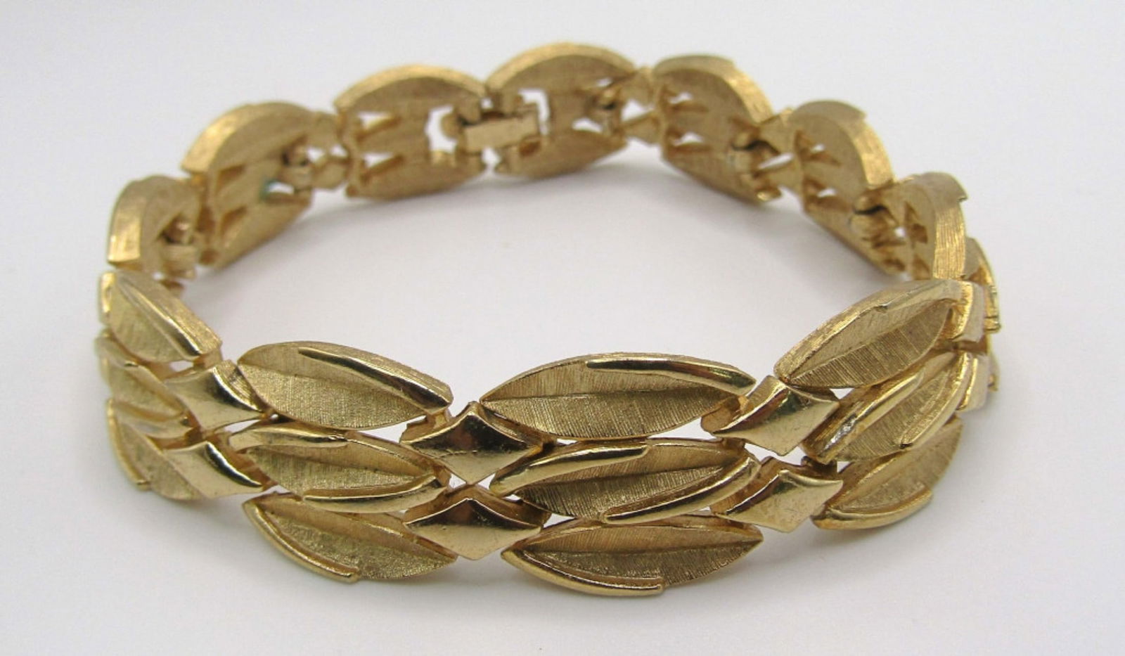 TRIFARI GOLD TONE BRACELET: 7IN IN LENGTH, STAMPED WITH BRAND ON OPEN BOX CLASP