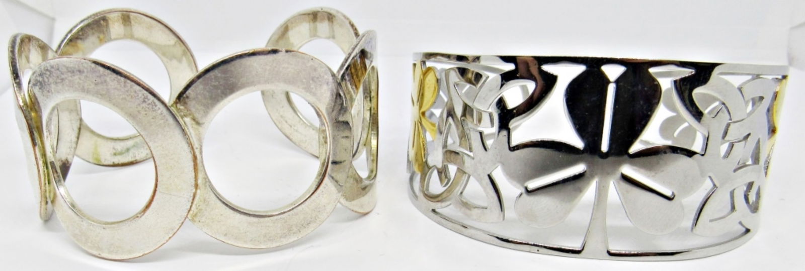 (2) FASHION CUFF BRACELETS: 1- FOUR-LEAF CLOVER SILVER AND GOLD TONE CUFF, 1- CIRCLE CUFF