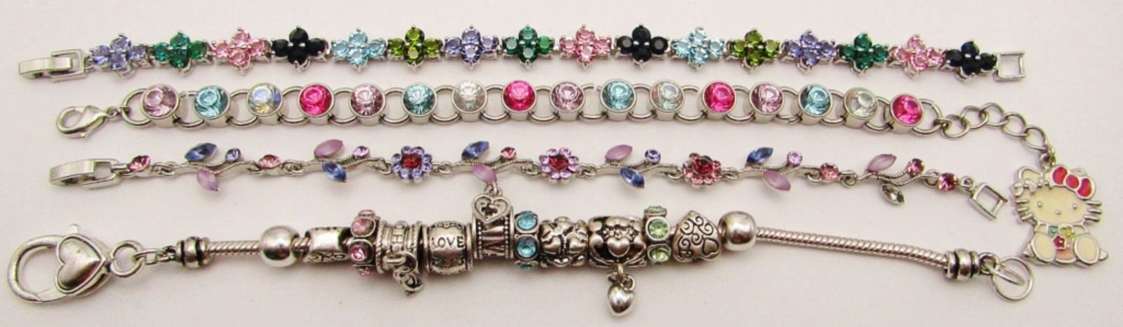 (4) Vintage Bracelets; Sanrio Hello Kitty Charm: Multicolor Rhinestone Enamel Tennis Bracelet, Silver Tone Multicolor Flower Design, Vintage Sliding Charm Bracelet, Purple Rhinestone Flower & Leaf Design (Missing 1 Rhinestone).