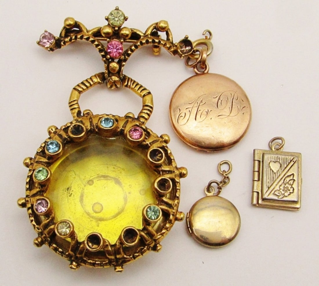 (4) GOLDTONE LOCKET PENDANTS: 3- ARE 1 TO 1 1/2IN LENGTH, 1- CIRCLE WITH ENGRAVED "A D", SMALL CIRCLE ONE, 1- A STORYBOOK, 1-ABOUT 2 1/2IN HAS PINK,WHITE, BLUE, GREEN STONES ALL AROUND, SOME STONES ARE MISSING AND WILL NEED A REPA