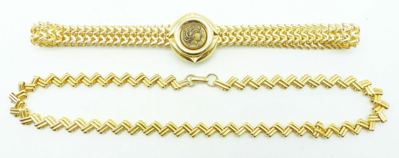 (2) WOMENS GOLD TONE NECKLACES: 18IN LONG GOLD TONE W/ OPEN BOX CLASP AVON BRAND AND STAMPED, CAMEO STYLE CHOKER 16IN LONG