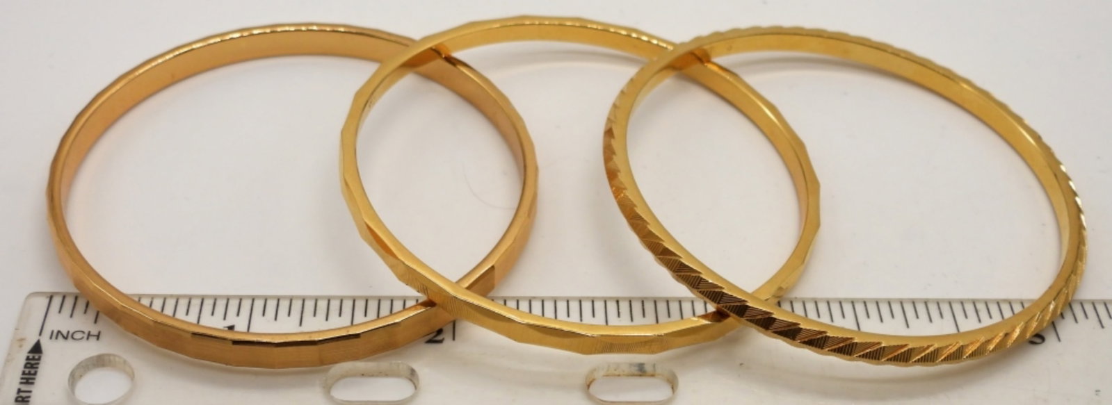 (3) MONET FASHION BRACELETS: GOLD TONE, STAMPED MONET ON THE INSIDE, EACH HAS A DIFFERENT ETCHED DESIGN