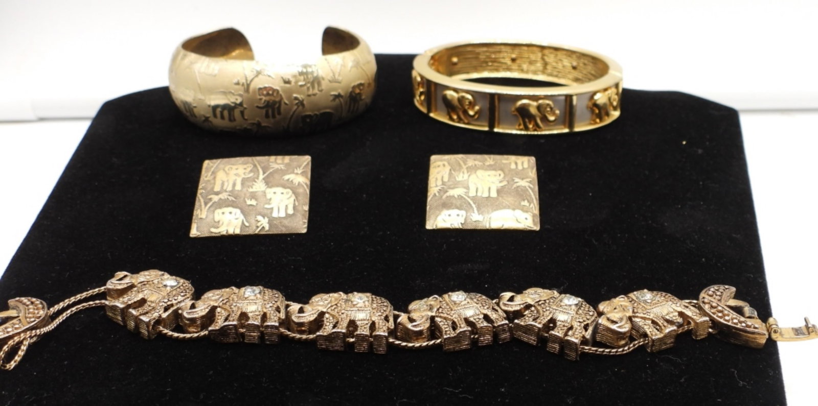 ELEPHANT BRACELET AND EARRING LOT: 1 CUFF BRACELET 3IN WIDE, 1 HINGE BRACELET, 1 8IN LONG WITH OPEN BOX CLASP ELEPHANT CHARM WITH CLEAR STONES,ELEPHANT ETCHED WITH PALM TREES ALL AROUND WITH A MATCHING PIERCED SQUARE EARRINGS