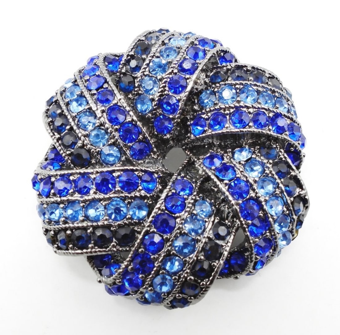 MONET VINTAGE BLUE RHINESTONE BROOCH: 2" FOLDED RIBBON STYLE BROOCH. GUNMETAL TONED. SIGNED ON BACK
