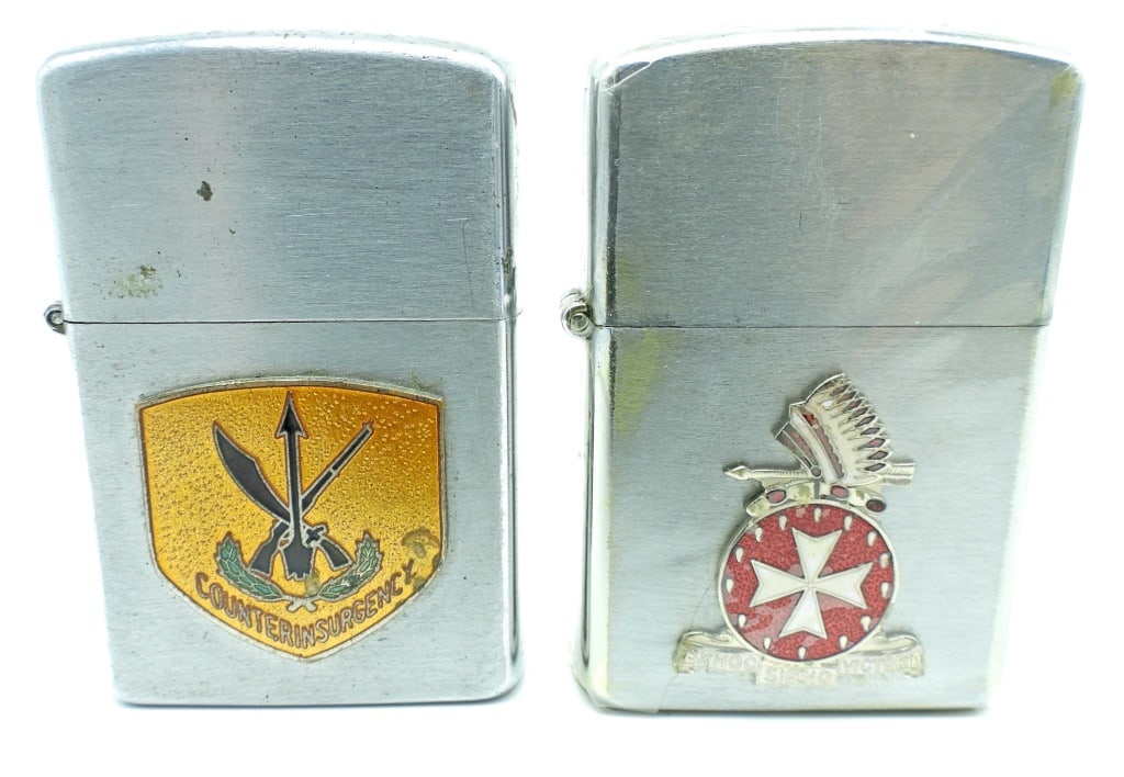 (2) MILTARY LOGO LIGHTERS: 1-PENGUIN NO.19531 " COUNTERINSURGENCY" LOGO ON THE FRONT, USED CONDITION, 1- WELLINGTON BOX 1064 (IN ORIGNAL BOX), SEALED IN CLEAR WRAPPING, "EXHOC SIGNO VICTORIA" LOGO ON THE FRONT
