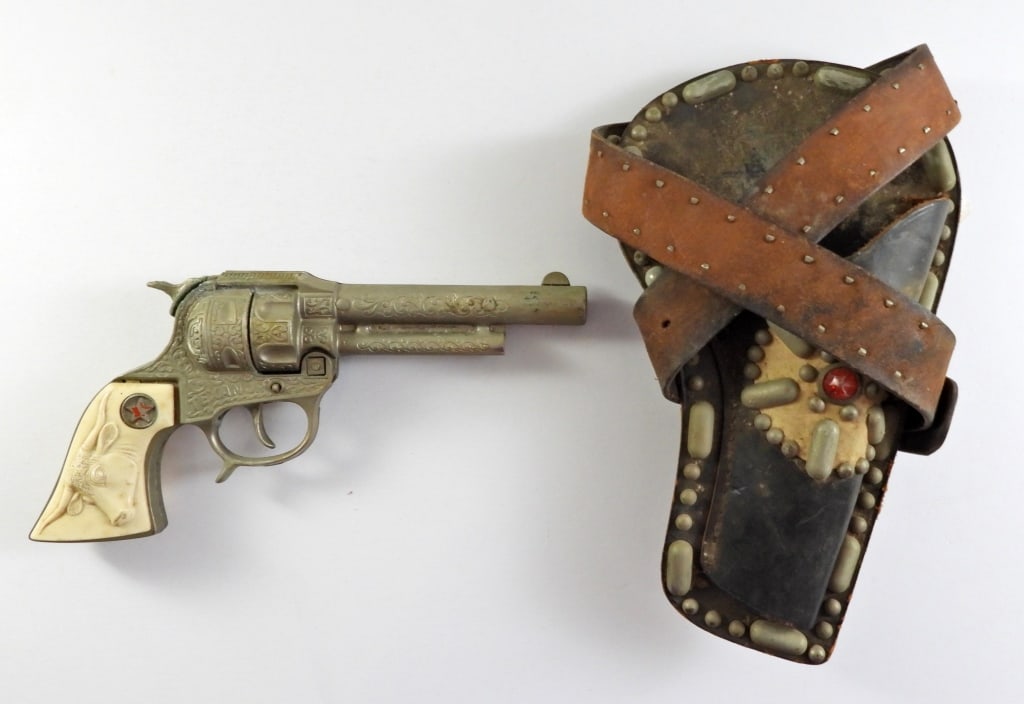 HUBLEY TEXAN JR CAP GUN W/HOLSTER BELT: 9IN LONG, A BULL AT THE HANDLE, TEXAN JR STAMPED ON BOTH SIDES, BOTTON WORKS TO OPEN THE CAP GUN AND LOCK NICELY, TIGGER IS STUCK (FOR REPAIR)