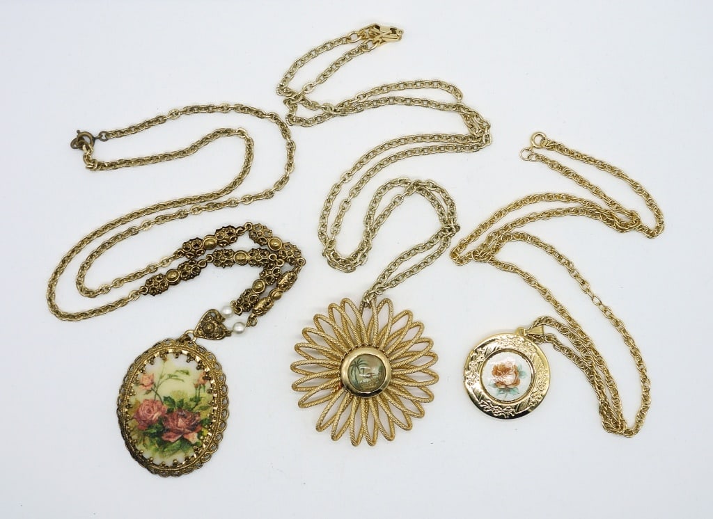 Vintage West Germany Pendant Necklace Lot: One gold tone West Germany sugared rose cameo on filigree 24 inch chain, one gold tone West Germany Guilloche peach rose enamel locket on 22 inch chain, and one gold tone West Germany Tropical Scene s