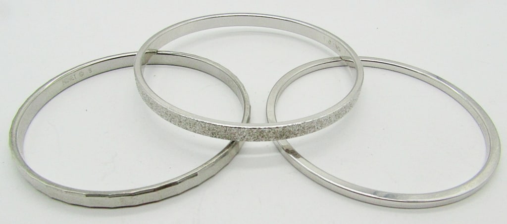 (3) MONET SILVER TONE BANGLES: ALL DIFFERENT. (2) 2.25" DIAMETER & (1) 2.5" DIAMETER. ALL SIGNED ON INSIDE.