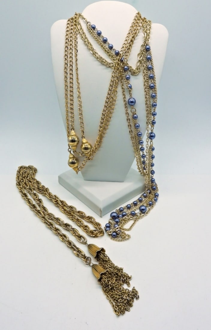 (3) Gold Tone & Pearl Long Fashion Necklaces: Gold Tone Long Etched Lariat Necklace with Tassels, 28 Inches. Gold Tone Long Chain with Golden Balls, 27 inches. Gold Tone Long Chain & Blue Faux Pearl Necklace, 26 Inches.
