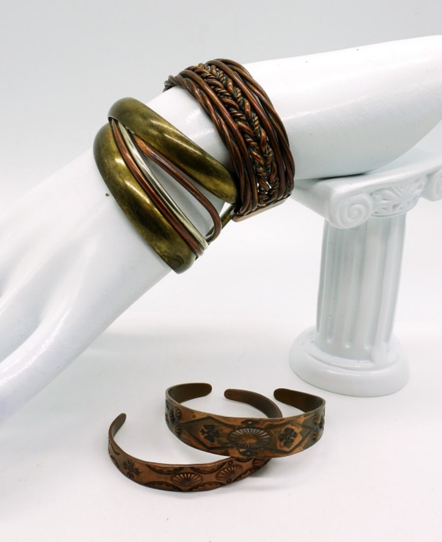 4 Vintage Copper Cuff Bracelets: Two thin Navajo style copper cuff bracelets, 5". One braided copper cuff bracelet, 7". One 3 tone cuff style bracelet in gold, silver & copper tone, 7".