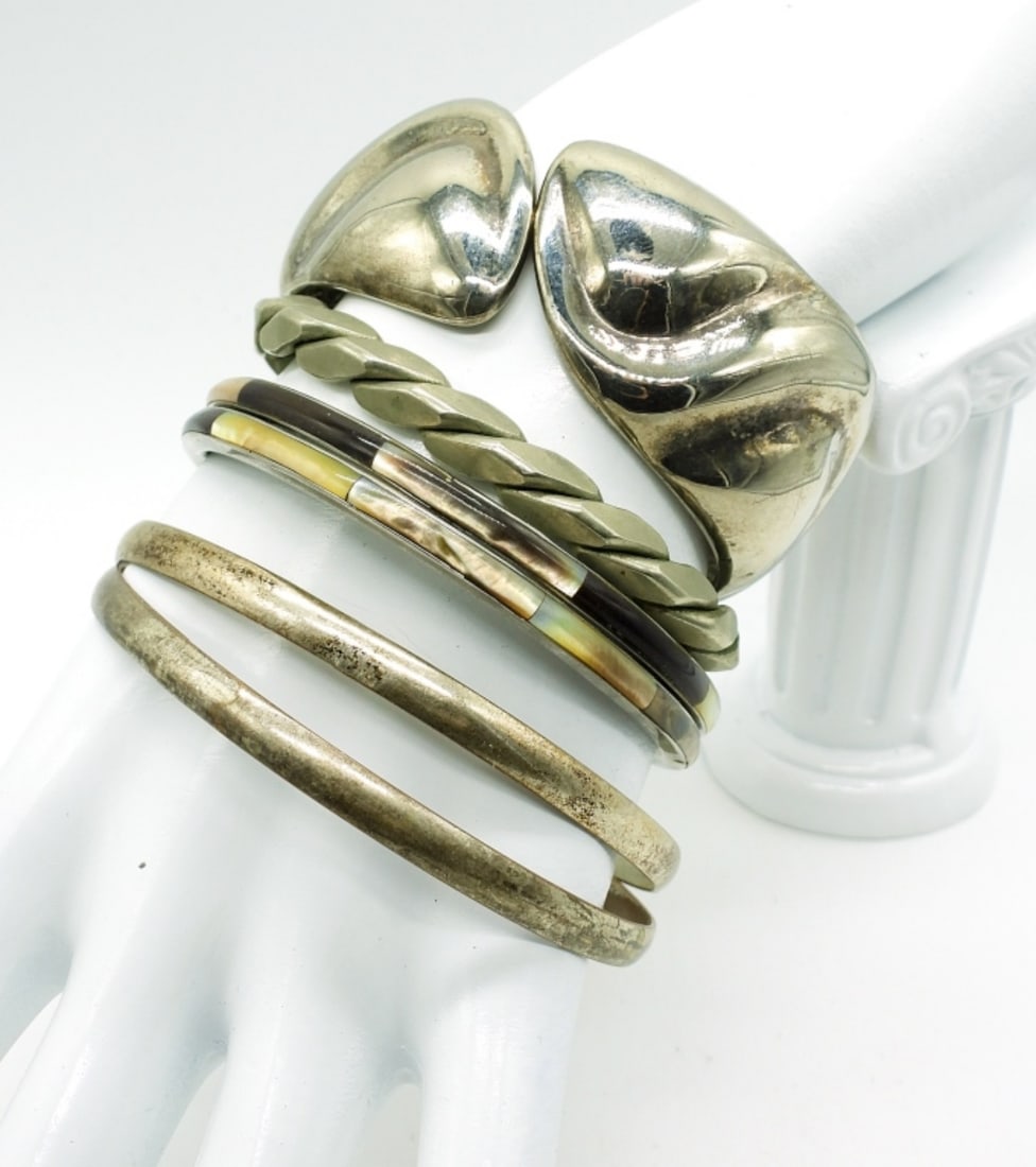 (6) Vintage 1980's Bracelets: Six Vintage 80's Bangle and Cuff Bracelets. Two are inlaid with shell - 7". Two Plain silver tone - 8". Two Cuffs with designs - 5" & 7".