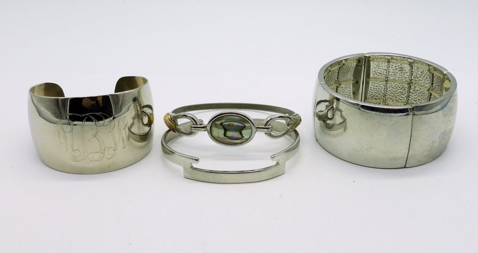(4) Bangles and Cuffs, Avon: 1-Silver tone Avon cuff bracelet (7"), 2-Gold and silver tone Avon Bangle with abalone insert (7"), 3-Silver tone wide cuff bracelet, engraved with "MBW" (5.5"), 4-Silver tone wide bangle (7").