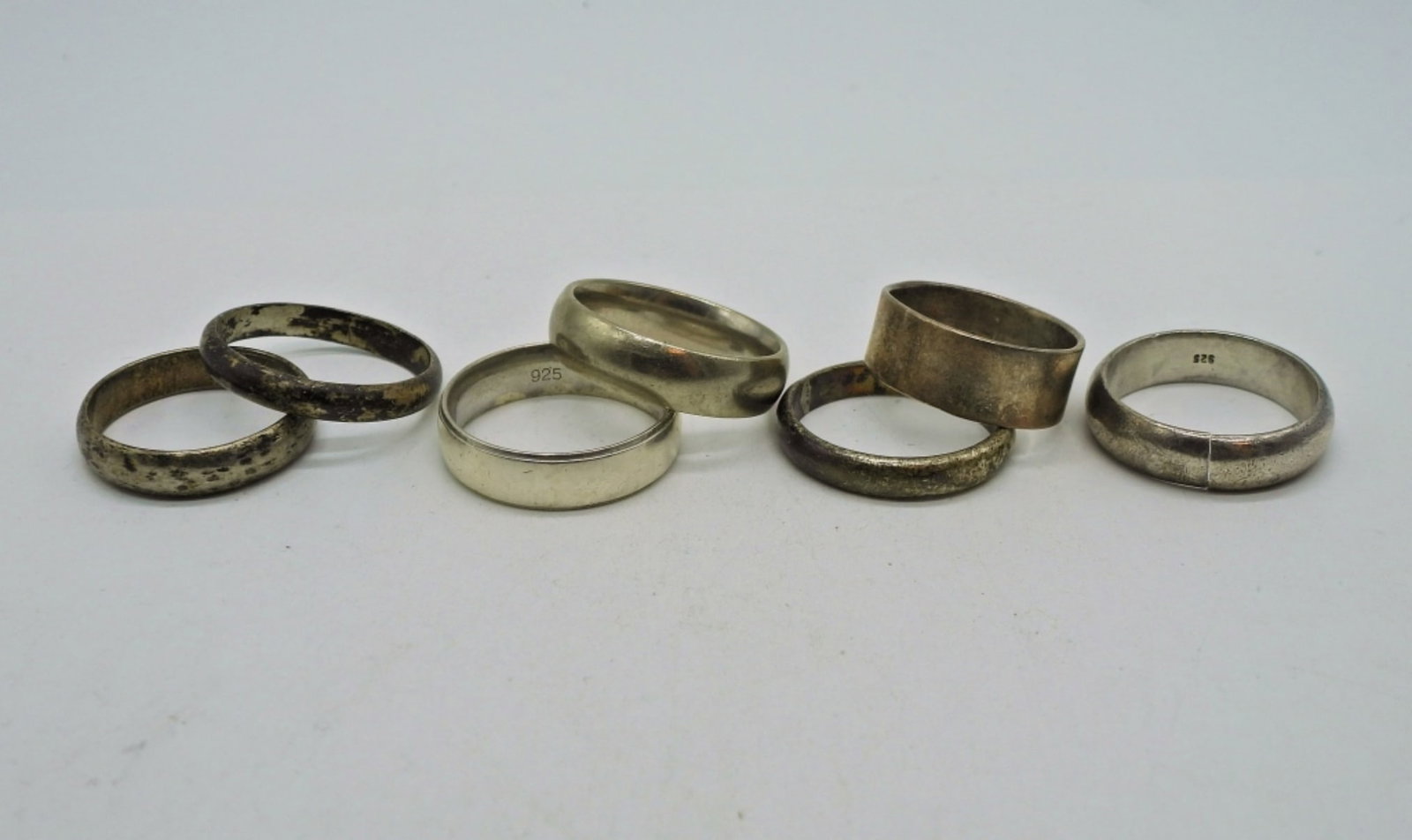 7 Sterling Bands - Vintage: Seven Marked 925 or Sterling Plain Bands. Sizes 8, 9, 9.5, 10, 11. One Band has been cut, please see photo. 21.5 DWT