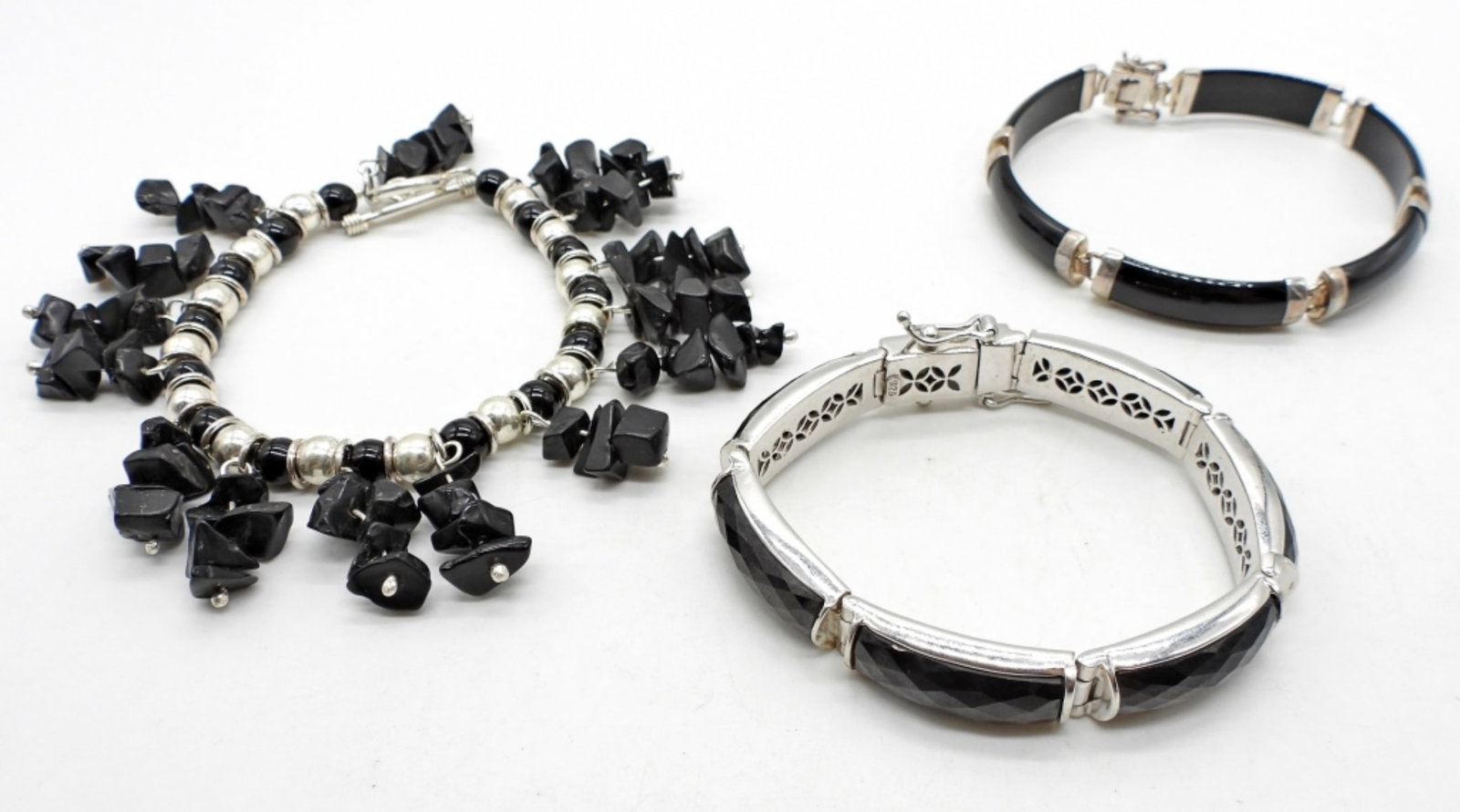 (3) STERLING BRACELETS: 28DWT, 8 1/2IN LONG BLACK INLAY WITH BOX CLASP, STAMPED 925 ON THE BACK, 1 6 1/2IN LONG BLACK AND STERLING BRACELET WITH BOX CLASP STAMPED 925 ON THE BACK, 1- 7 1/2IN LONG DANGLED BLACK ONYX CHUCKS WI