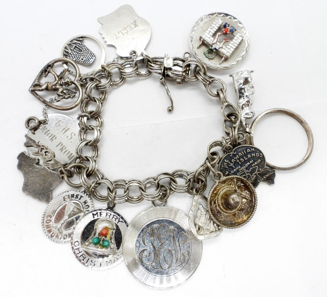 VINTAGE CHARM BRACELET FROM 1960'S: 40 DWT. STAMPED STERLING. WITH 14 CHARMS MOST MARKED STERLING OR 925.