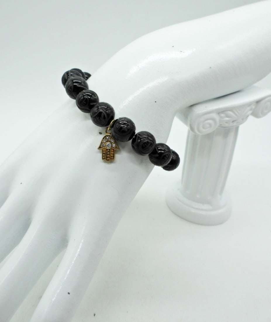 Carved Black Onyx Bracelet with Hamsa: Stretchy 7" Carved Black Onyx Beaded Bracelet with Gold Tone Hamsa Charm.