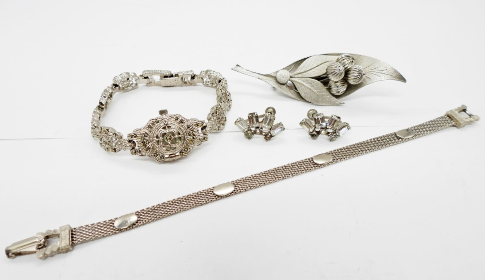 VINTAGE MARCASITE WATCH & MORE: VINTAGE SILVER TONE MARCASITE COVERED FACE WATCH (NOT TESTED!!), VINTAGE BRACELET (7"), BRUSHED METAL LEAF BROOCH & VINTAGE RHINESTONE SCREW BACK EARRINGS.