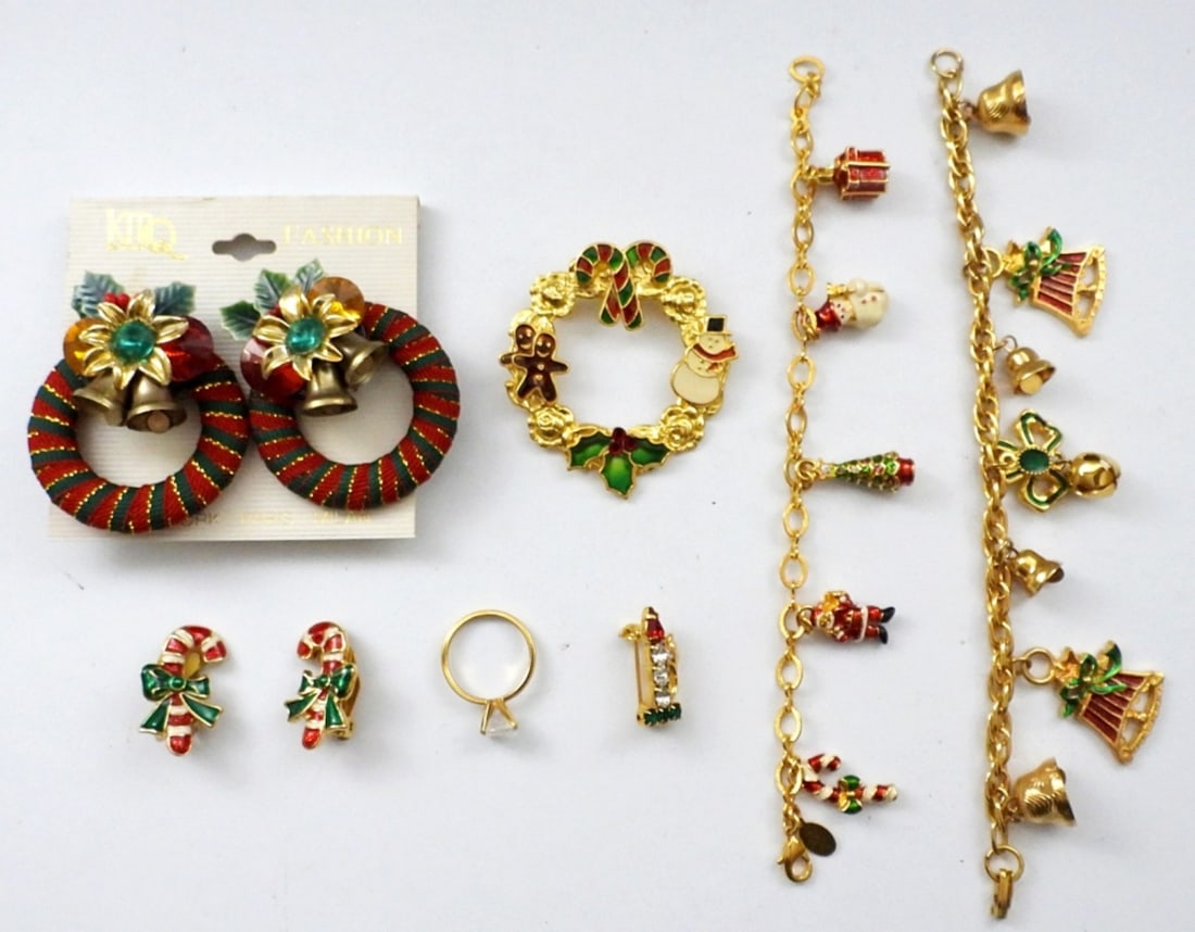 GOLD TONE CHRISTMAS THEMED JEWELRY LOT: (2) 7" CHRISTMAS CHARM BRACELETS, (2) BROOCH PINS, (2) PAIRS OF CLIP-ON EARRINGS, GOLD TONE RING WITH LARGE CLEAR GEMSTONE- SIZE 7