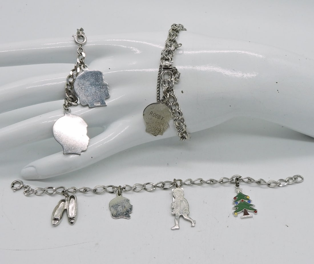 (3) VINTAGE CHARM BRACELETS: 24 DWT. 7", 5" & 7.5" IN LENGTH W/ A TOTAL OF (7) CHARMS MOST STAMPED STERLING.