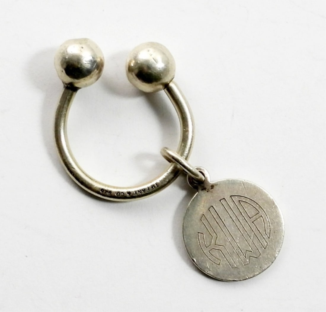 TIFFANY & CO 925 PERSONALIZED KEYCHAIN: CURVED BARBEL STYLE KEYCHAIN (MARKED TIFFANY & CO 925) WITH A CHARM ENGRAVED WITH "KWA" AND MARKED "TIFFANY & CO 925" ON BACK. 6.4 DWT