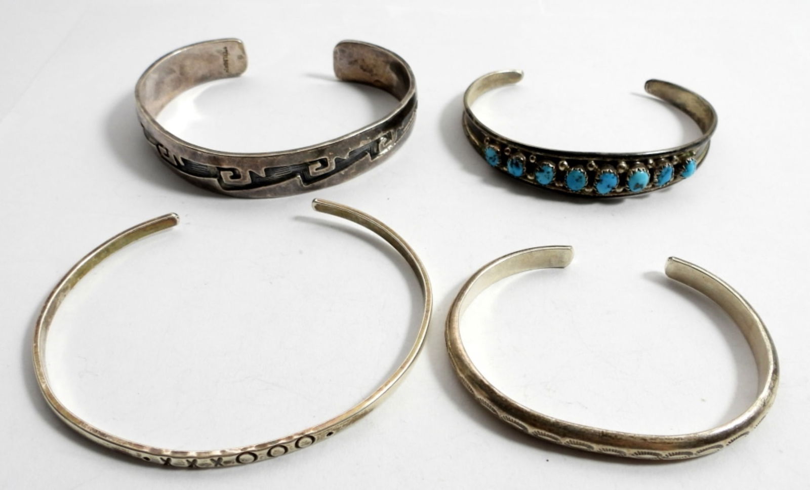 (4)SOUTHWEST STERLING CUFF BRACELETS: (1) TURQUOISE 6 1/2", (1) CHILDS 5 3/4" (1) THICK TRIBLE 7" (1) XXXOOO 8" (40 DWT)
