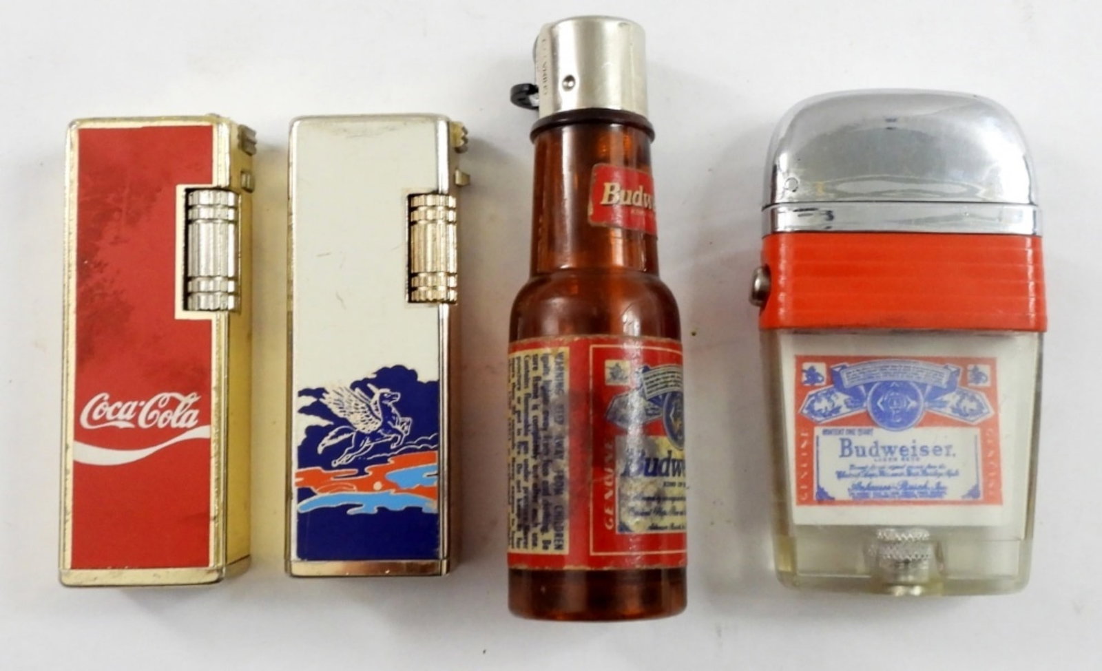 (4) VINTAGE PROMO LIGHTERS-COCA COLA & MORE: SUNEX COCA-COLA PROMOTIONAL LIGHTER, FIRED, MADE IN KOREA. HAV-A-LITER UNICORN LIGHTER-FIRED, MADE IN KOREA. TWO BUDWEISER VINTAGE PLASTIC LIGHTERS -FIRED.