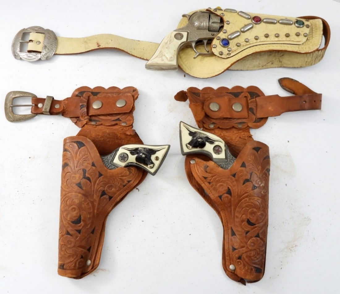 (3) TEXAN JR ANTIQUE CAP GUNS & HOLSTER: ONE HOLSTER IS MISSING PART OF THE BELT AND ONE CAP GUN IS BROKE AND COULD USE FOR PARTS