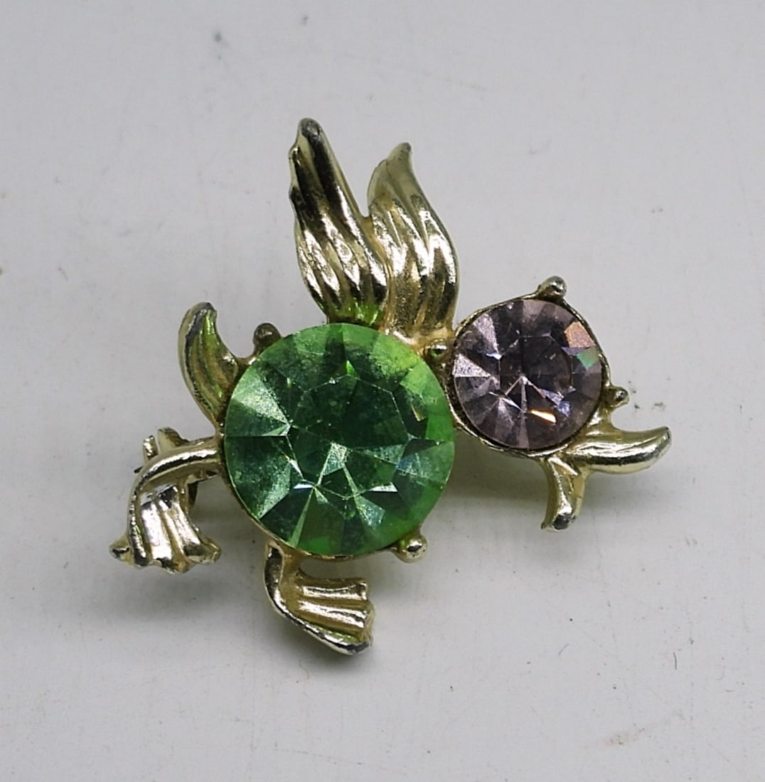 URANIUM GLASS DUCK BROOCH: VINTAGE GOLD TONE DUCK BROOCH WITH TWO GEMSTONES. GREEN GEMSTONE IS URANIUM GLASS. 1" PIN.