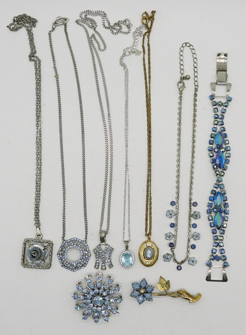 BLUE TOPAZ COLORED LOT OF 9: SILVER AND GOLD TONE. 5 NECKLACES, 14-23". ONE BRACELET 7". TWO BROOCHES, SILVERTONE IS CORO, FLORAL IS 12K GOLD PLATED.