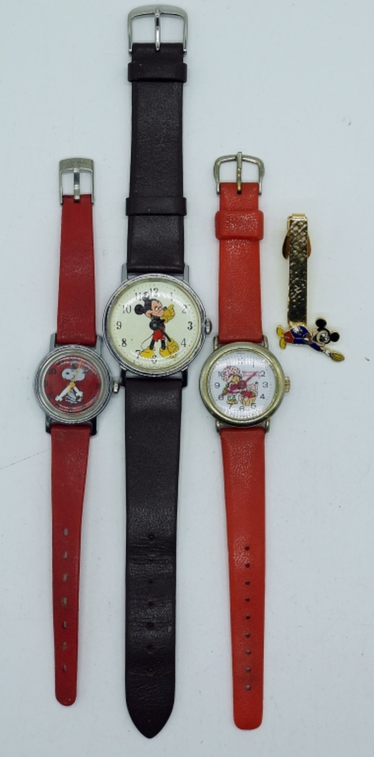 SNOOPY, MICKEY, STRAWBERRY SHORTCAKE WATCHES: VINTAGE WATCHES & MICKEY MOUSE TIE TACK. SNOOPY RED WATCH, BROWN BAND MICKEY MOUSE WATCH, VINTAGE STRAWBERRY SHORTCAKE WATCH WITH RED BAND.