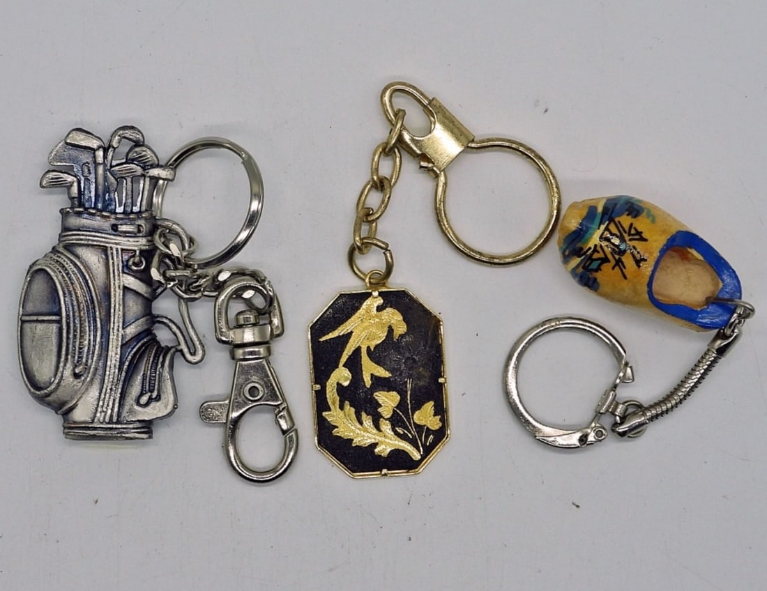 (3) FUN KEYCHAINS: PEWTER GOLF BAG, WOODEN CLOG, GOLD & BLACK BIRDS.