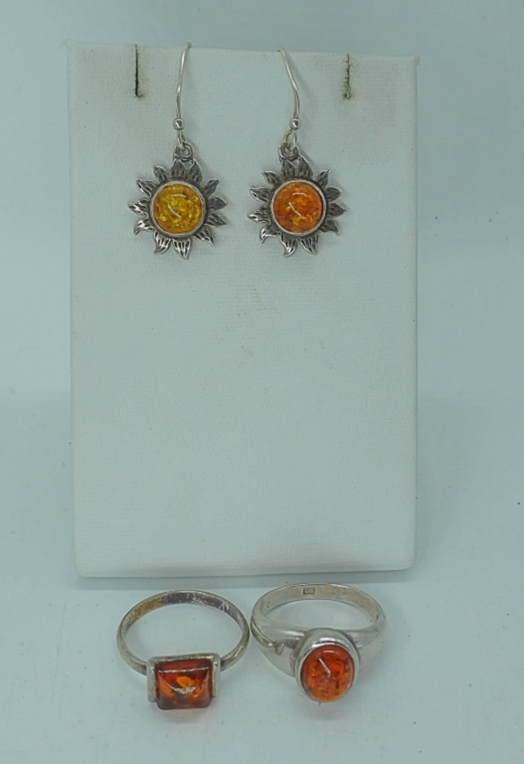 AMBER STERLING EARRINGS & RINGS: TWO STERLING RINGS WITH AMBER GEMSTONES, SIZES 8 & 8.5. ONE PAIR OF SUN/SUNFLOWER PIERCED EARRINGS WITH AMBER CENTERS. 6.2DWT