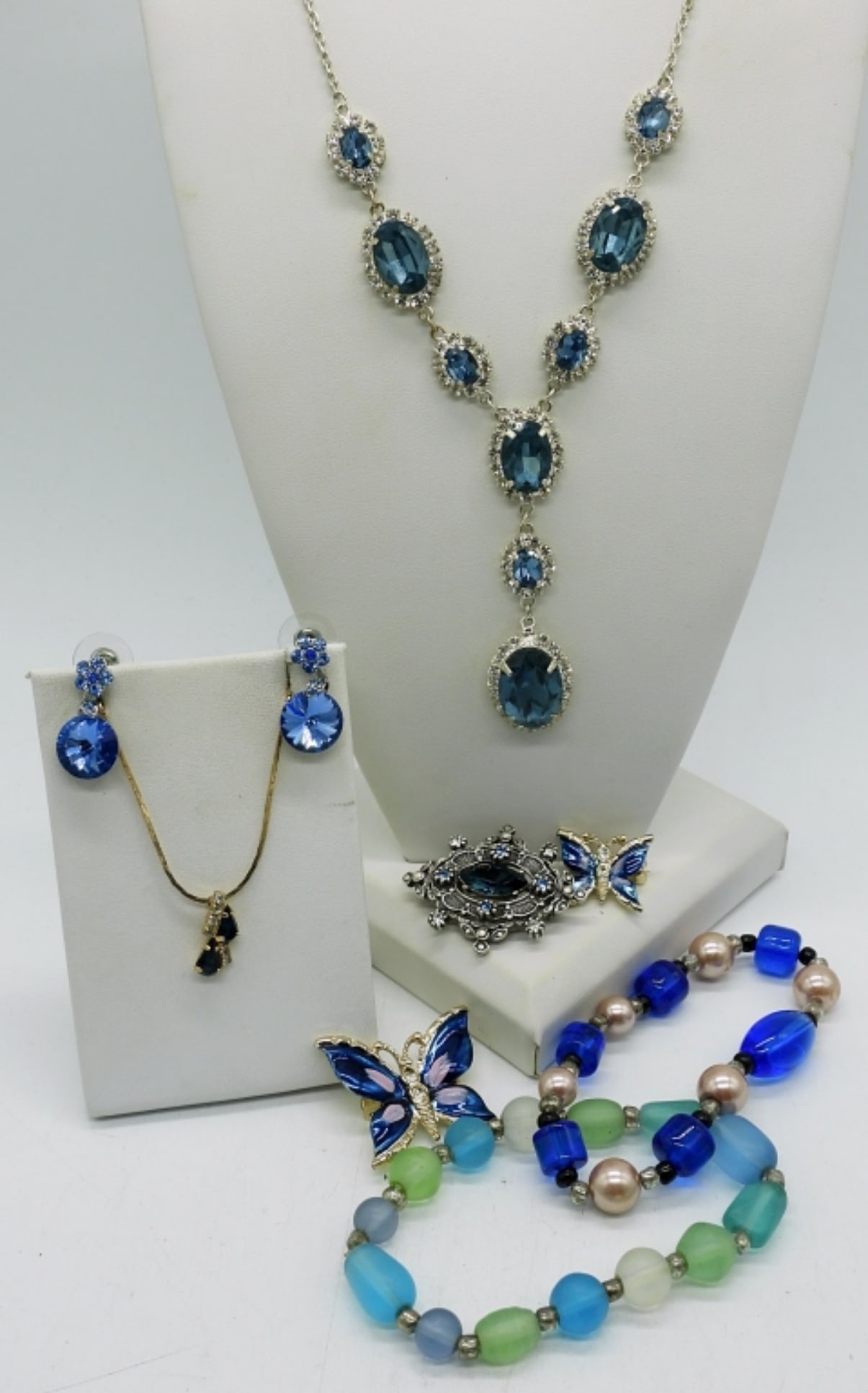 SAPPHIRE LIKE JEWELRY SET: NECKLACES ARE 25" & 17". 3 BROOCHES, 1 PAIR PIERCED EARRINGS. TWO STRETCHY BRACELETS