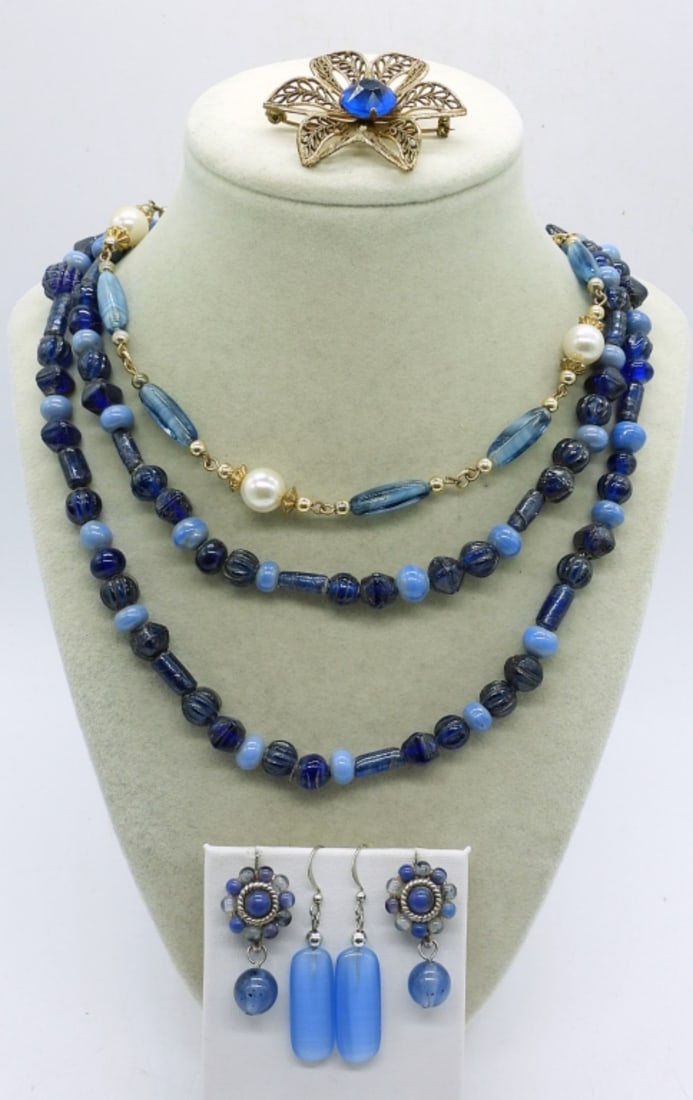 BLUE NECKLACES, EARRINGS & BROOCH: TWO BLUE AND GOLD TONE NECKLACES, 16" & 36". PIERCED EARRINGS & GOLD TONE FLORAL BROOCH.